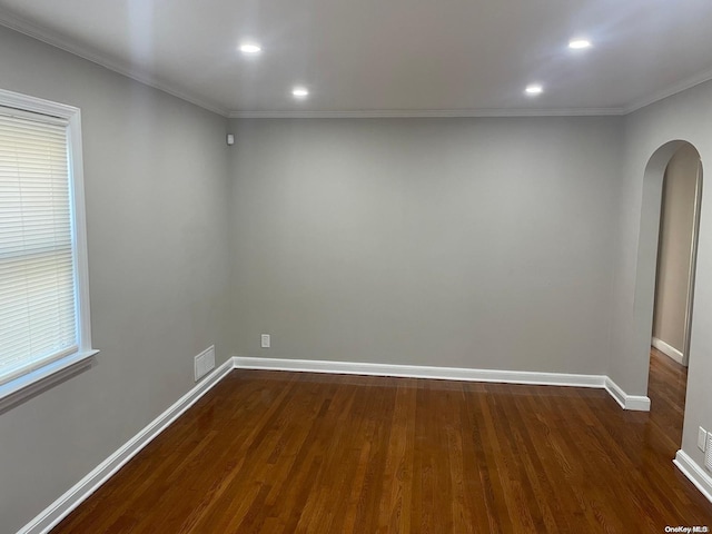 empty room with crown molding and dark hardwood / wood-style floors