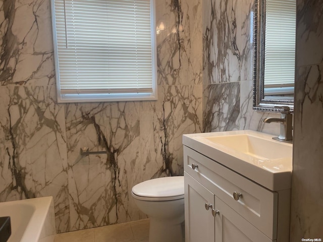 bathroom with a tub, tile walls, tile patterned flooring, vanity, and toilet