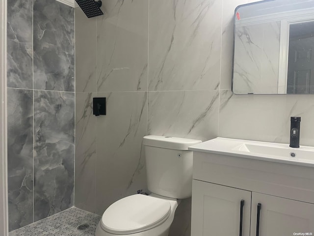 bathroom featuring walk in shower, vanity, toilet, and tile walls