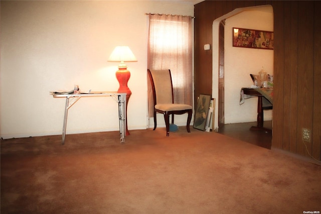 sitting room featuring dark carpet