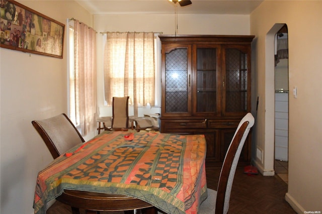 dining space with dark parquet floors and ceiling fan