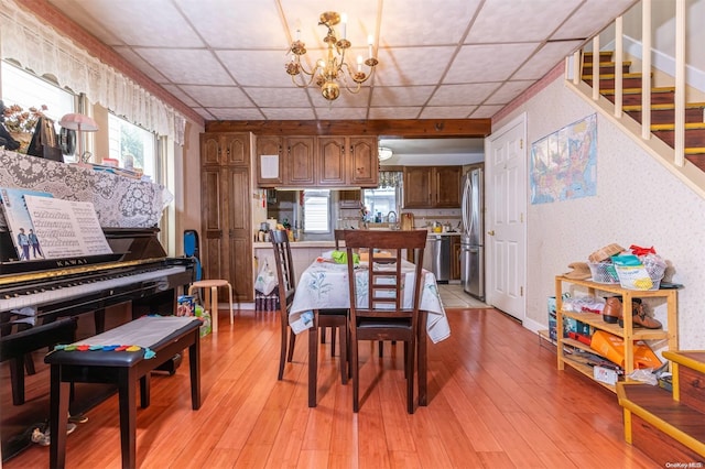 dining room with light hardwood / wood-style floors and an inviting chandelier