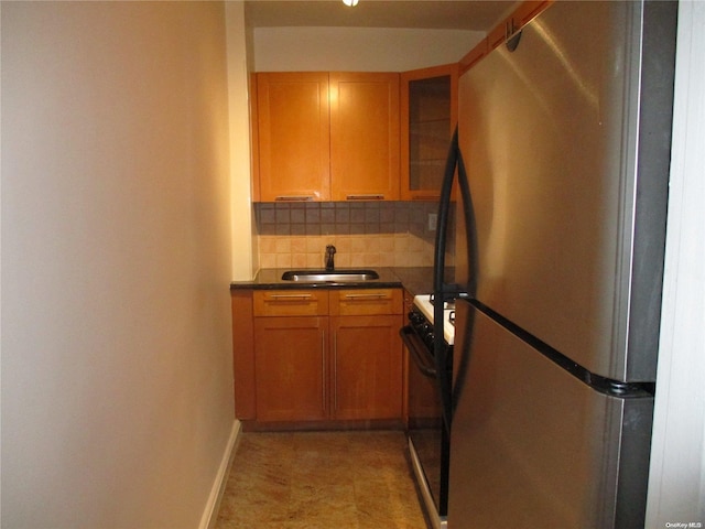 kitchen with backsplash, stainless steel refrigerator, black range with electric stovetop, and sink