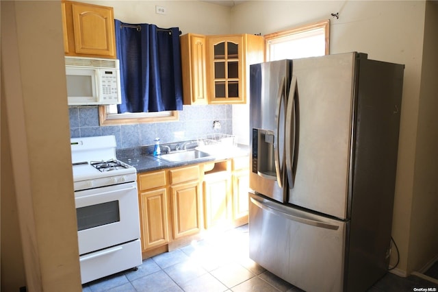 kitchen featuring tasteful backsplash, white appliances, sink, light tile patterned floors, and light brown cabinets