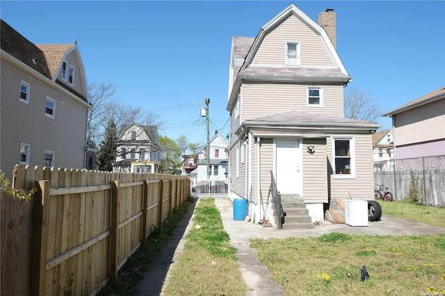 back of house featuring a lawn