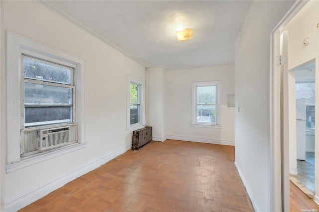 spare room featuring radiator heating unit and wood-type flooring