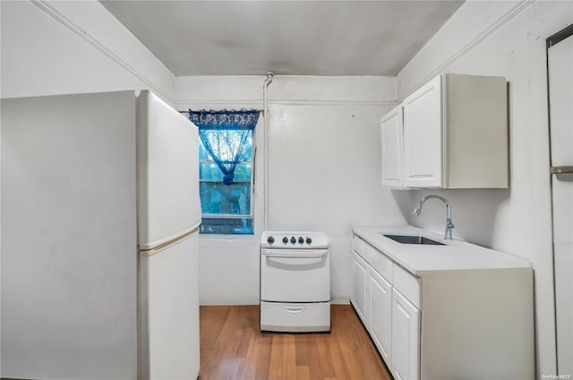 kitchen with light wood-type flooring, white appliances, white cabinets, and sink