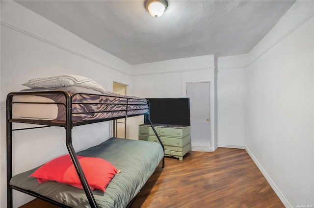 bedroom with dark wood-type flooring