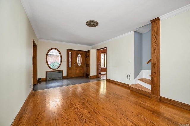 foyer featuring radiator heating unit, ornamental molding, and dark wood-type flooring