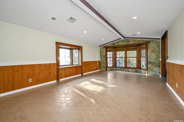 spare room with wooden walls and lofted ceiling with beams