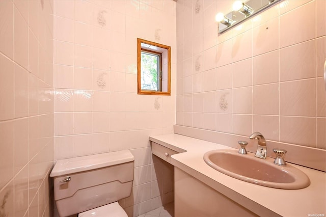 bathroom featuring vanity, tile walls, and toilet