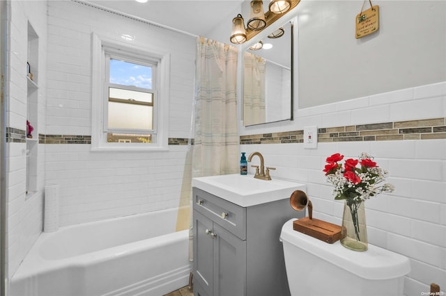 bathroom with vanity, toilet, and tile walls