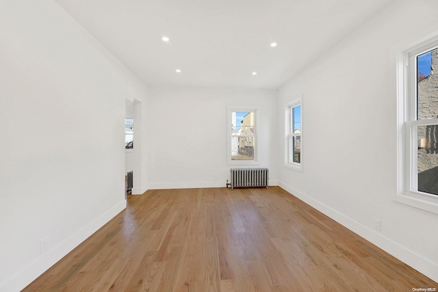 unfurnished room with light hardwood / wood-style floors and radiator