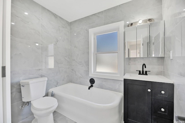 bathroom featuring a washtub, vanity, tile walls, and toilet