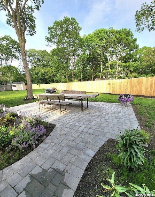 view of property's community featuring a yard and a patio