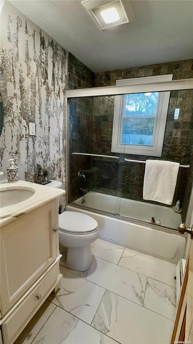 full bathroom featuring vanity, toilet, and bath / shower combo with glass door