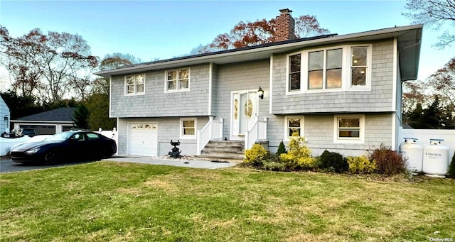 split foyer home featuring a front yard and a garage