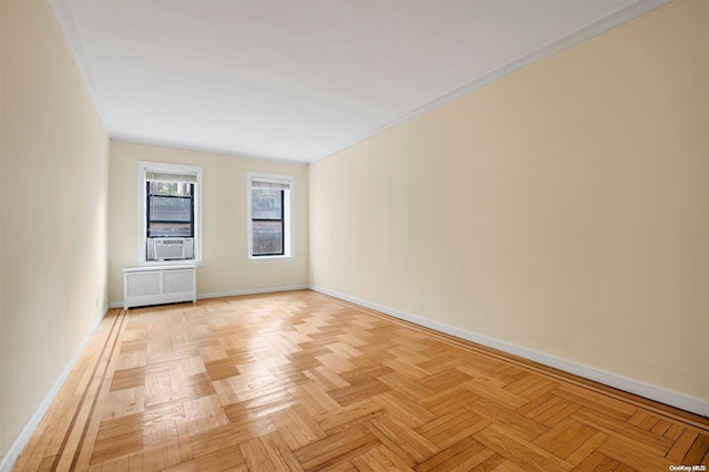 empty room featuring cooling unit, crown molding, and light parquet flooring