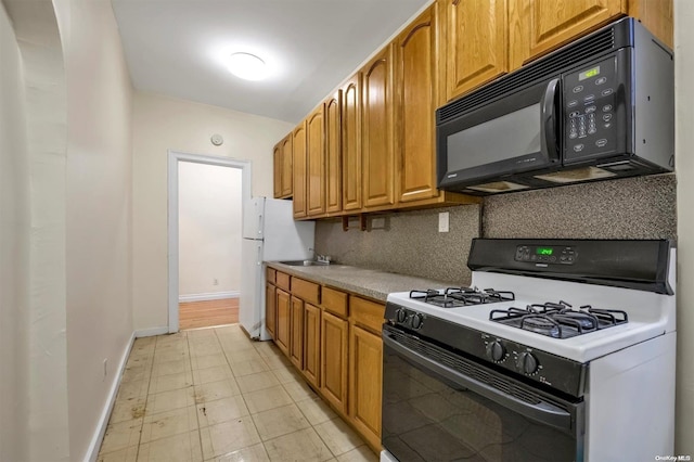 kitchen with tasteful backsplash, sink, and gas range gas stove