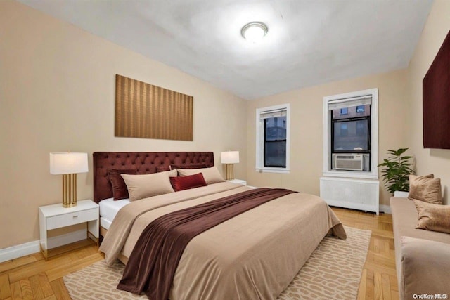 bedroom featuring radiator, light parquet flooring, and cooling unit