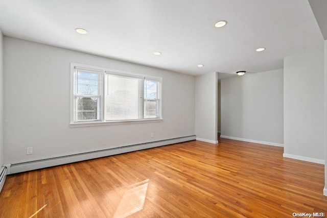 unfurnished room featuring light hardwood / wood-style floors and a baseboard radiator