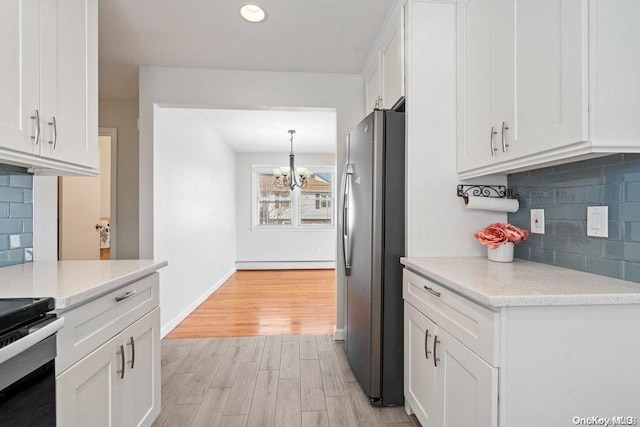 kitchen featuring tasteful backsplash, white cabinetry, stainless steel refrigerator, and light hardwood / wood-style flooring