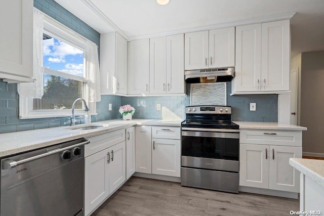 kitchen featuring white cabinetry, sink, stainless steel appliances, and light wood-type flooring