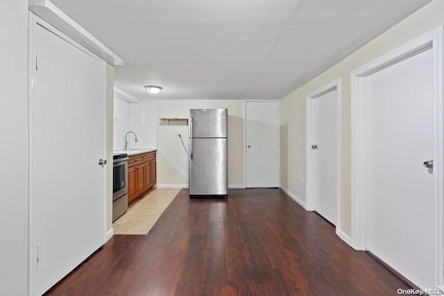 kitchen with tasteful backsplash, sink, dark wood-type flooring, and appliances with stainless steel finishes