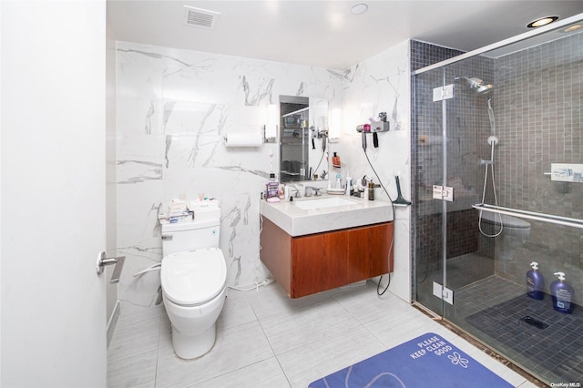 bathroom with vanity, toilet, tile walls, and a shower with shower door