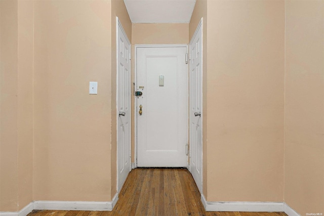 corridor with hardwood / wood-style floors