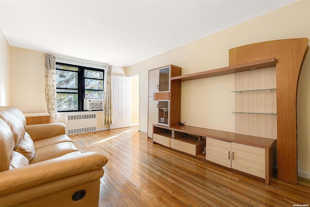 living room featuring hardwood / wood-style floors, cooling unit, and radiator