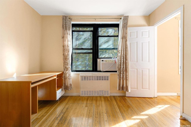 interior space featuring cooling unit, light wood-type flooring, and radiator