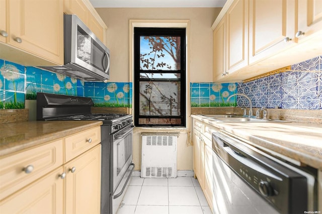 kitchen featuring light tile patterned flooring, sink, backsplash, and appliances with stainless steel finishes