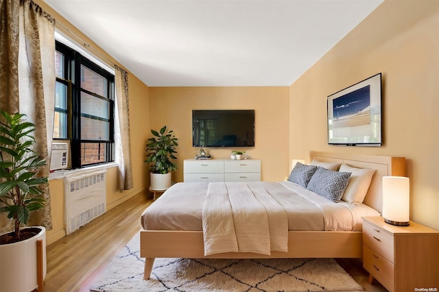 bedroom featuring light hardwood / wood-style floors and radiator heating unit