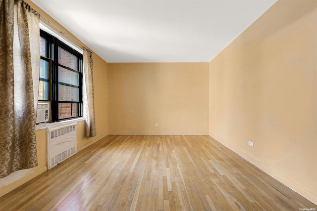 unfurnished living room featuring light hardwood / wood-style floors and radiator heating unit