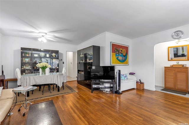 living room with hardwood / wood-style floors, ceiling fan, and ornamental molding