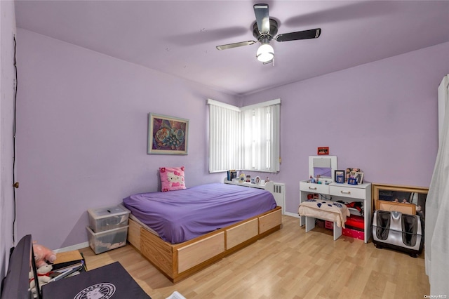 bedroom with radiator, light hardwood / wood-style flooring, and ceiling fan