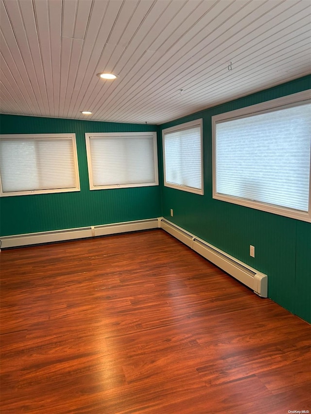 unfurnished room with wood-type flooring, baseboard heating, and wood ceiling