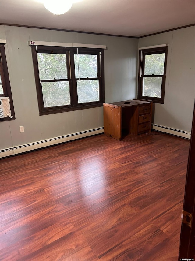 empty room featuring baseboard heating, plenty of natural light, and dark hardwood / wood-style floors