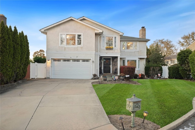 view of property featuring a garage and a front lawn