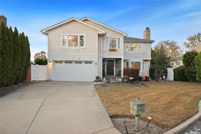 front facade with a garage and a front lawn