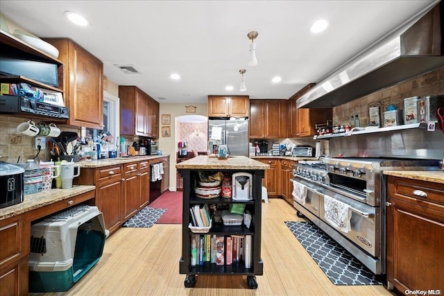 kitchen with a center island, light wood-type flooring, stainless steel appliances, and range hood