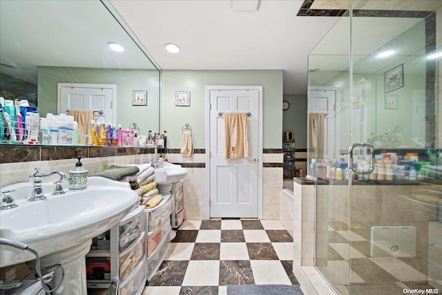 bathroom with a shower with door and tile walls