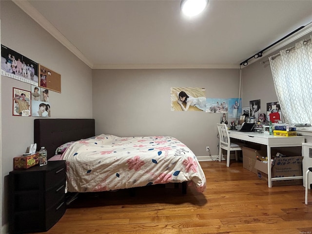 bedroom featuring ornamental molding and light hardwood / wood-style flooring