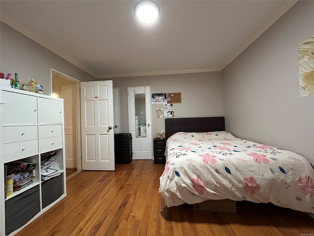 bedroom with ornamental molding and hardwood / wood-style flooring