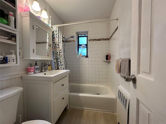 full bathroom featuring toilet, hardwood / wood-style floors, shower / bathtub combination with curtain, vanity, and radiator heating unit