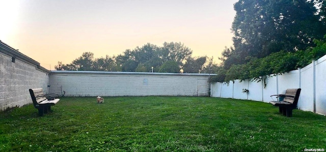 yard at dusk with a fenced backyard