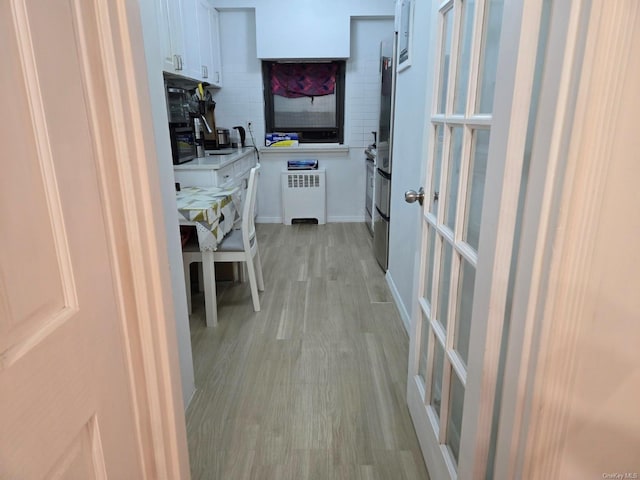 interior space featuring light wood-style floors and radiator heating unit