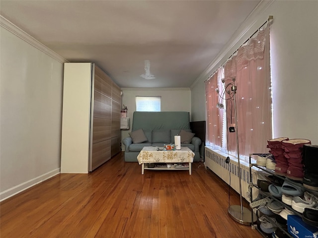 living room with baseboards, hardwood / wood-style floors, radiator heating unit, and crown molding