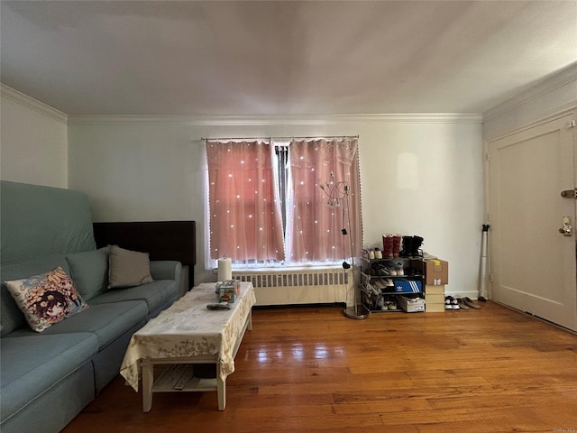 living area with radiator heating unit, wood finished floors, and crown molding